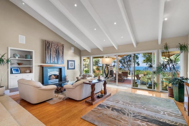 living room with lofted ceiling with beams and light wood-type flooring