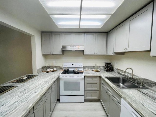 kitchen featuring gray cabinetry, white appliances, sink, and light hardwood / wood-style flooring