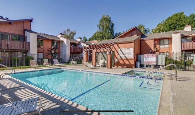 view of pool with a patio area and a hot tub