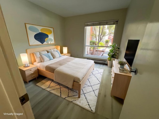 bedroom featuring light hardwood / wood-style floors and a baseboard radiator