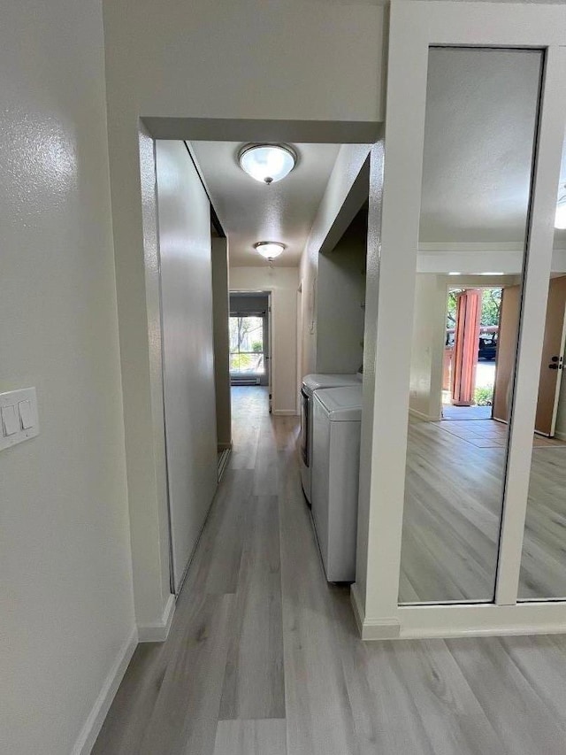 corridor featuring separate washer and dryer and light hardwood / wood-style floors