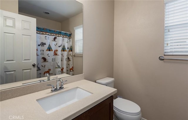 bathroom featuring vanity, a shower with shower curtain, and toilet