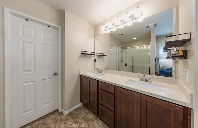 bathroom featuring a shower with door and vanity