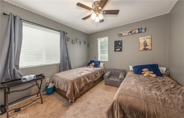 carpeted bedroom featuring multiple windows and ceiling fan