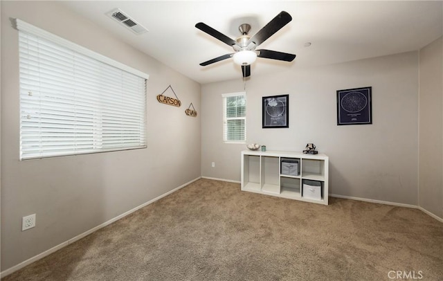 unfurnished office featuring ceiling fan and light colored carpet