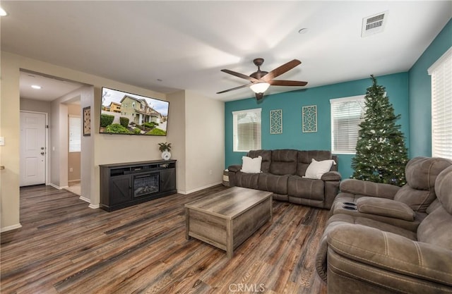 living room featuring ceiling fan and dark wood-type flooring