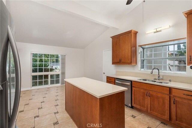 kitchen featuring appliances with stainless steel finishes, a center island, ceiling fan, sink, and vaulted ceiling with beams