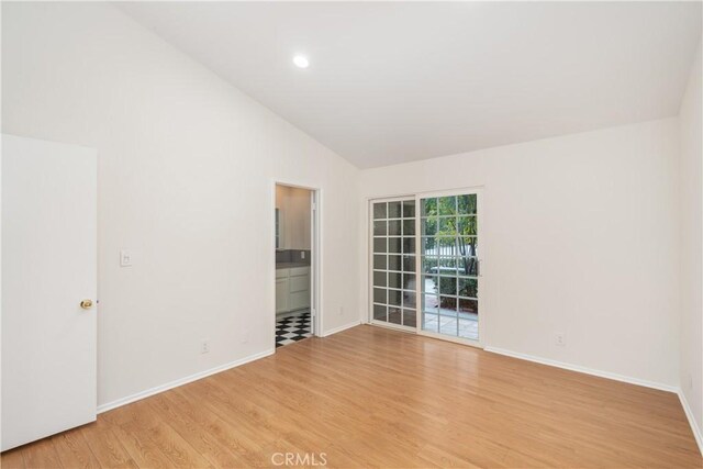 empty room with high vaulted ceiling and light wood-type flooring