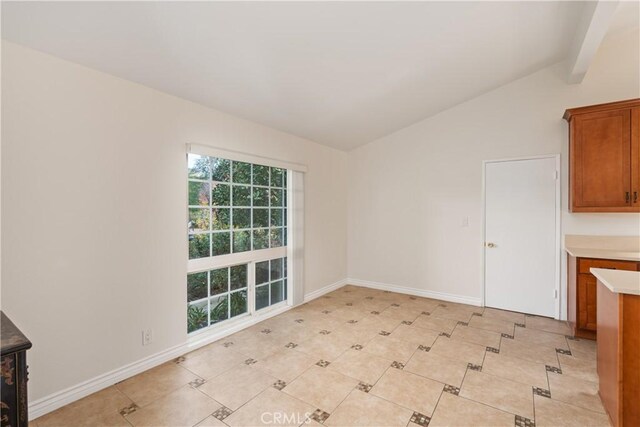 unfurnished dining area with lofted ceiling with beams