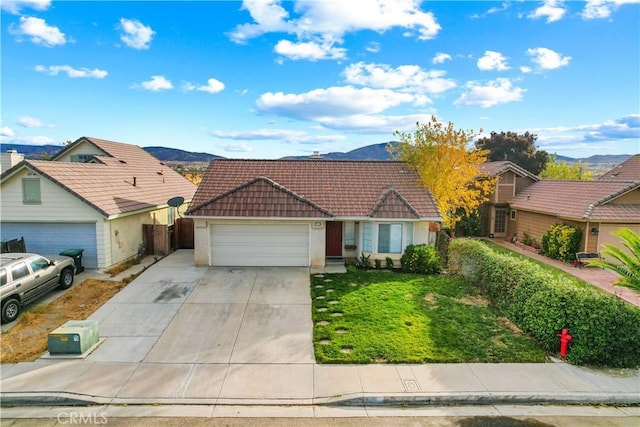 ranch-style home with a mountain view, a garage, and a front yard