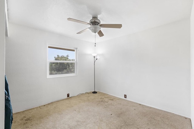 carpeted spare room with a ceiling fan