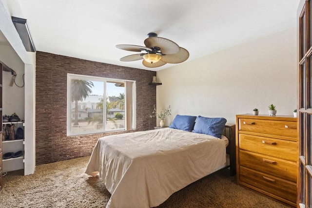 bedroom featuring brick wall, carpet, and a ceiling fan