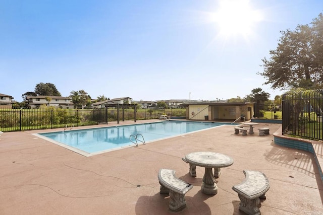 pool with a patio area and fence