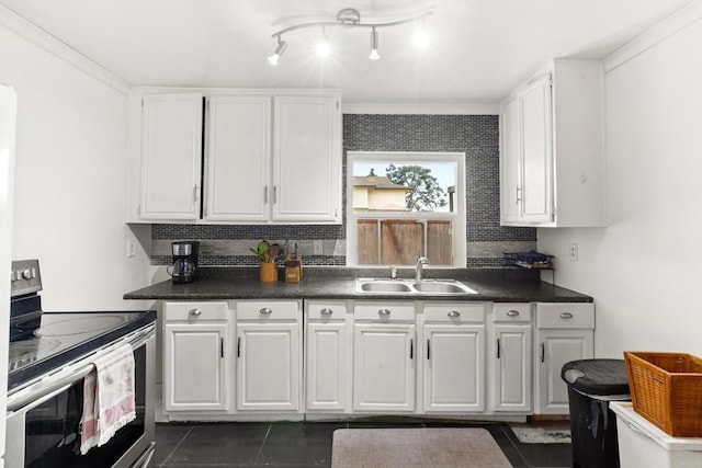 kitchen featuring dark countertops, stainless steel electric range, a sink, and white cabinets