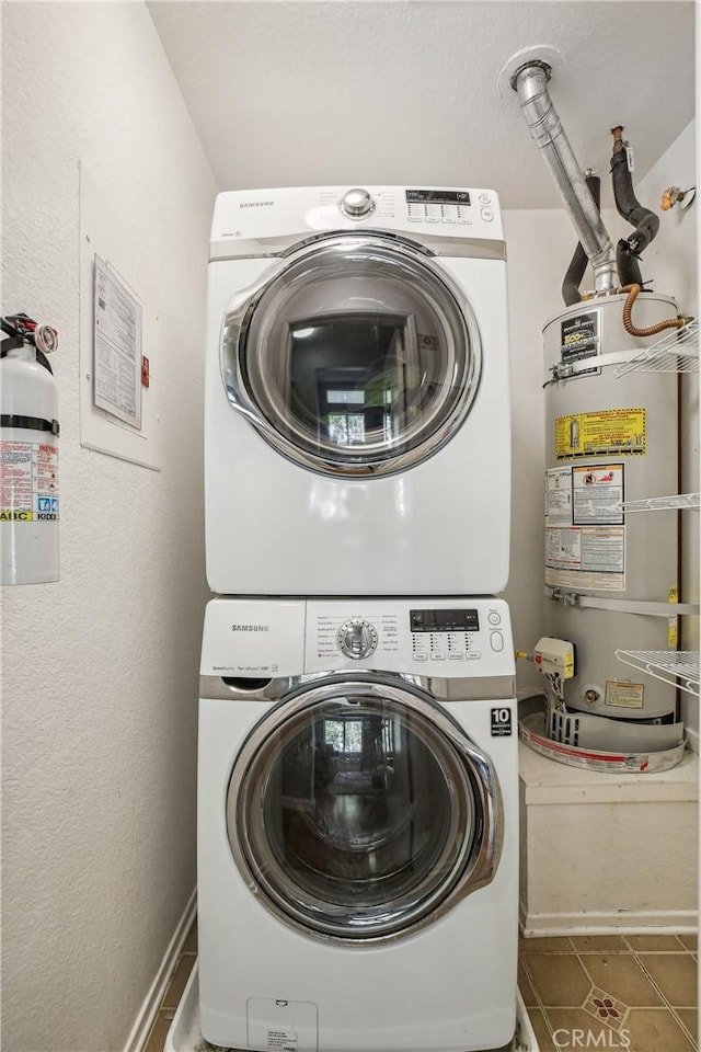 washroom with tile patterned flooring, stacked washer and dryer, and water heater