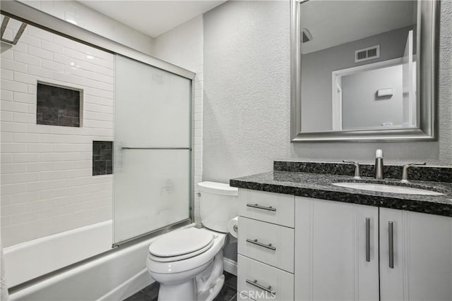 full bathroom featuring combined bath / shower with glass door, vanity, and toilet