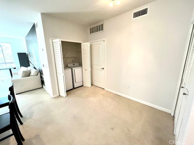 unfurnished bedroom with light carpet and separate washer and dryer