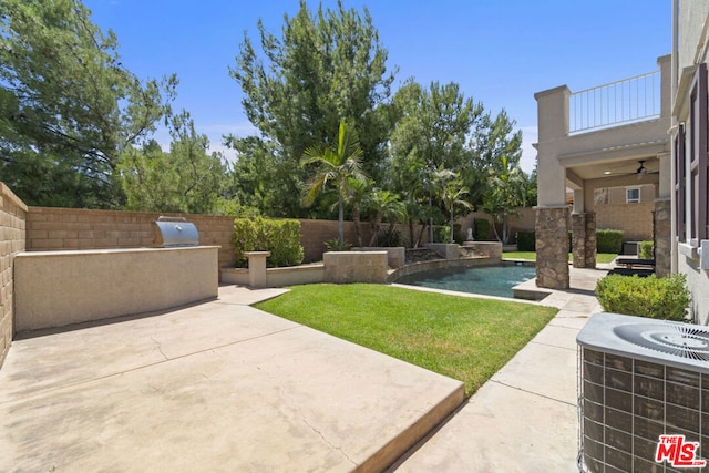 view of yard featuring an outdoor kitchen, a balcony, a patio area, and a fenced in pool