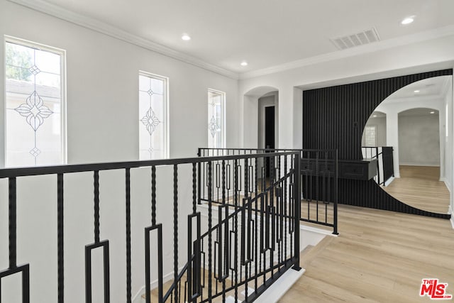 hallway with light hardwood / wood-style flooring and crown molding