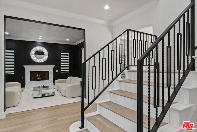 stairway featuring hardwood / wood-style floors and ornamental molding