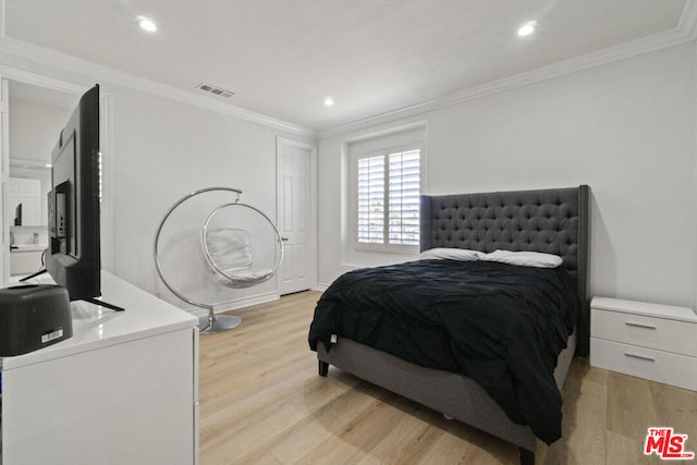 bedroom with crown molding and light hardwood / wood-style flooring