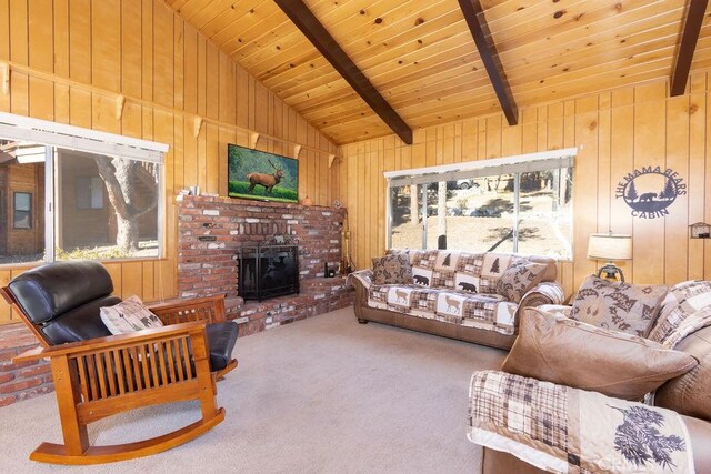 living room with beam ceiling, a wood stove, wood walls, and carpet