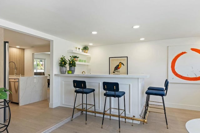 bar featuring dishwasher and light hardwood / wood-style floors