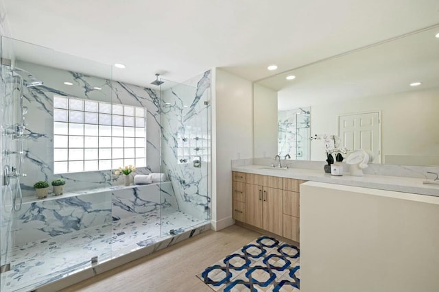 bathroom with hardwood / wood-style flooring, vanity, and a shower with door