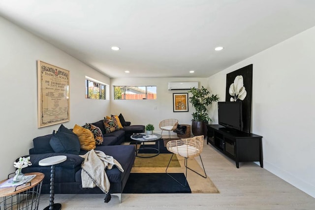 living room with a wall mounted AC and light hardwood / wood-style flooring