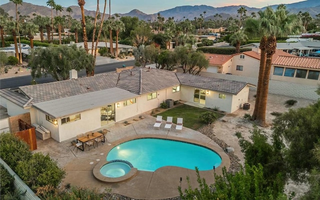 view of swimming pool featuring a mountain view, a patio, an in ground hot tub, and central air condition unit