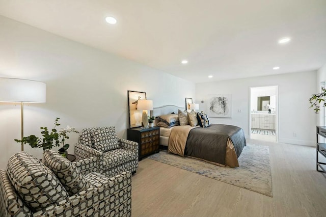 bedroom featuring ensuite bathroom and light hardwood / wood-style floors