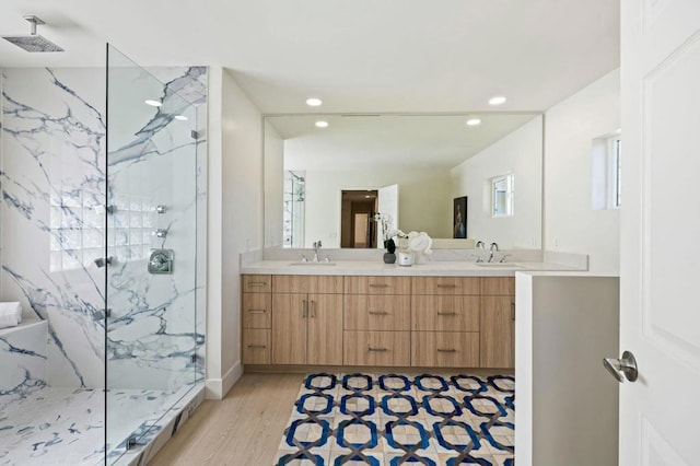 bathroom featuring hardwood / wood-style flooring, vanity, and tiled shower