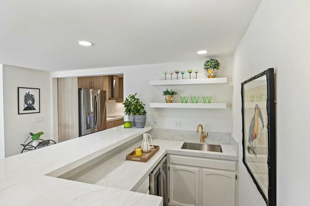 kitchen featuring white cabinets, sink, wine cooler, light stone countertops, and stainless steel fridge with ice dispenser