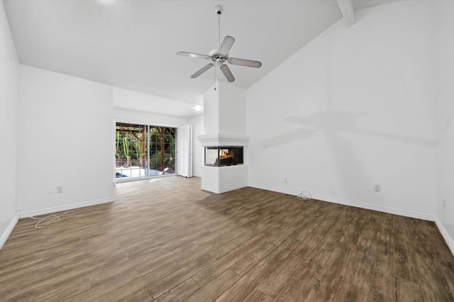 unfurnished living room with beam ceiling, ceiling fan, a multi sided fireplace, high vaulted ceiling, and wood-type flooring