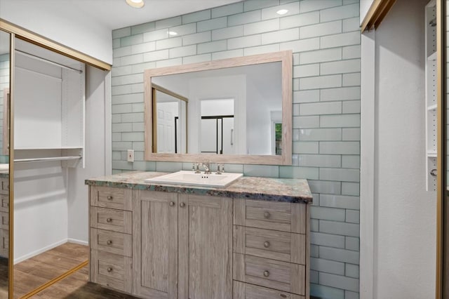 bathroom featuring vanity, hardwood / wood-style flooring, and tile walls