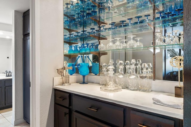 bar featuring light tile patterned floors and sink