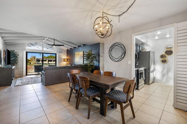 tiled dining area featuring ceiling fan with notable chandelier and lofted ceiling