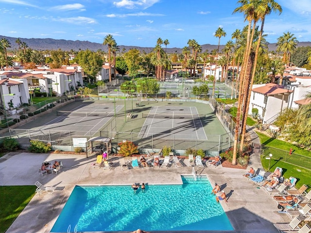 view of swimming pool with a mountain view and tennis court