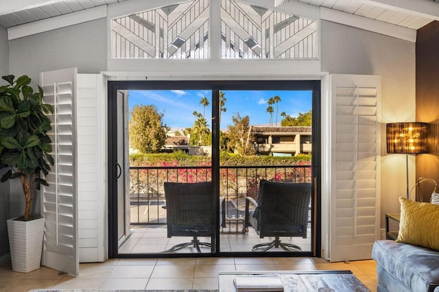 doorway to outside featuring light tile patterned floors, lofted ceiling with beams, and a notable chandelier