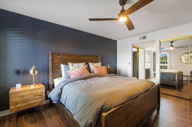 bedroom featuring ceiling fan, wood-type flooring, and ensuite bath