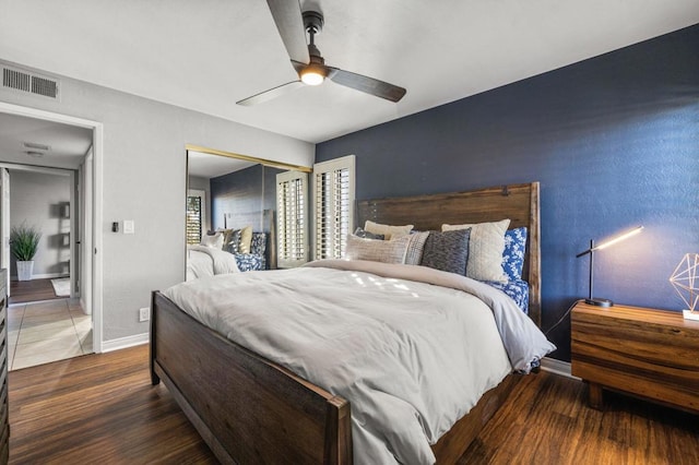 bedroom with a closet, dark hardwood / wood-style floors, and ceiling fan