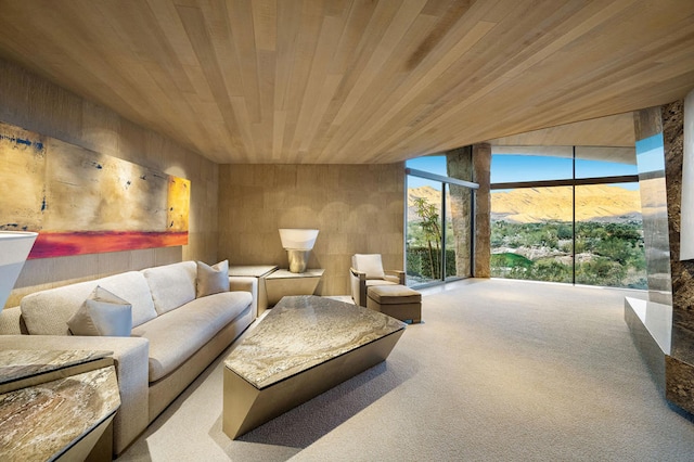 living room with carpet flooring, a mountain view, expansive windows, and wood ceiling