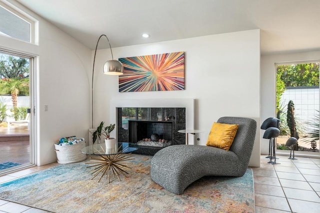 sitting room with a fireplace and light tile patterned floors