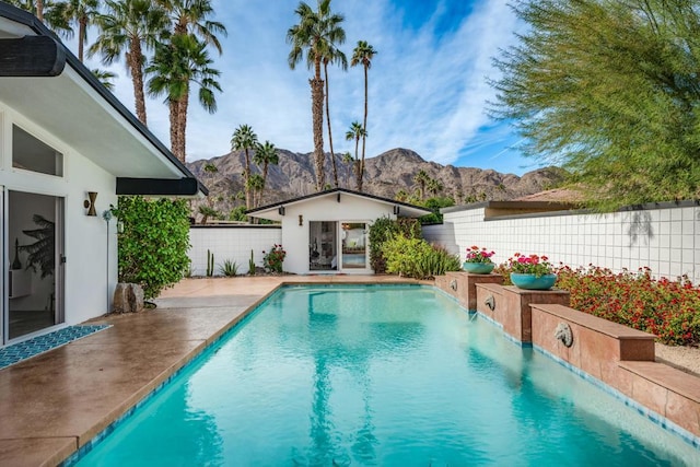 view of swimming pool with a mountain view and an outbuilding