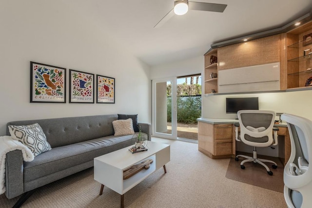 office area featuring ceiling fan, light colored carpet, and built in desk