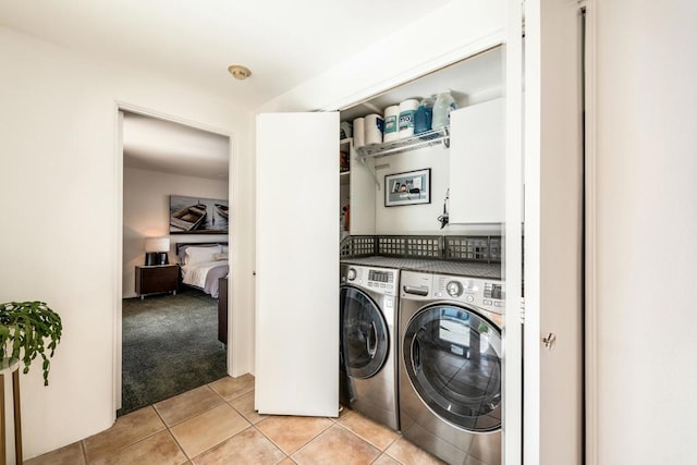 washroom featuring washer and clothes dryer and light tile patterned flooring