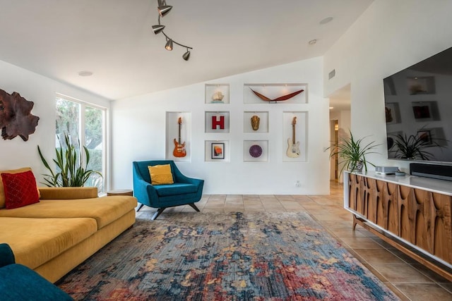 living room with light tile patterned floors, rail lighting, and vaulted ceiling