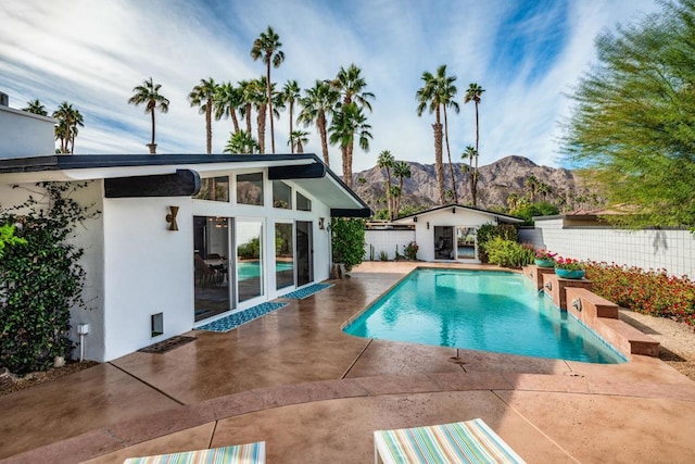 view of swimming pool featuring a mountain view and a patio