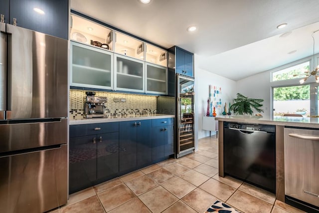 kitchen with blue cabinetry, dishwasher, stainless steel refrigerator, lofted ceiling, and light tile patterned flooring