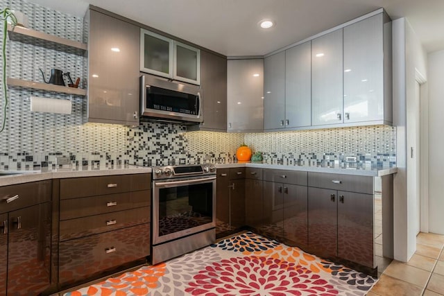 kitchen with light tile patterned floors, backsplash, and appliances with stainless steel finishes